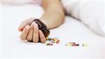 spilled bottle of pills on victim's hand 